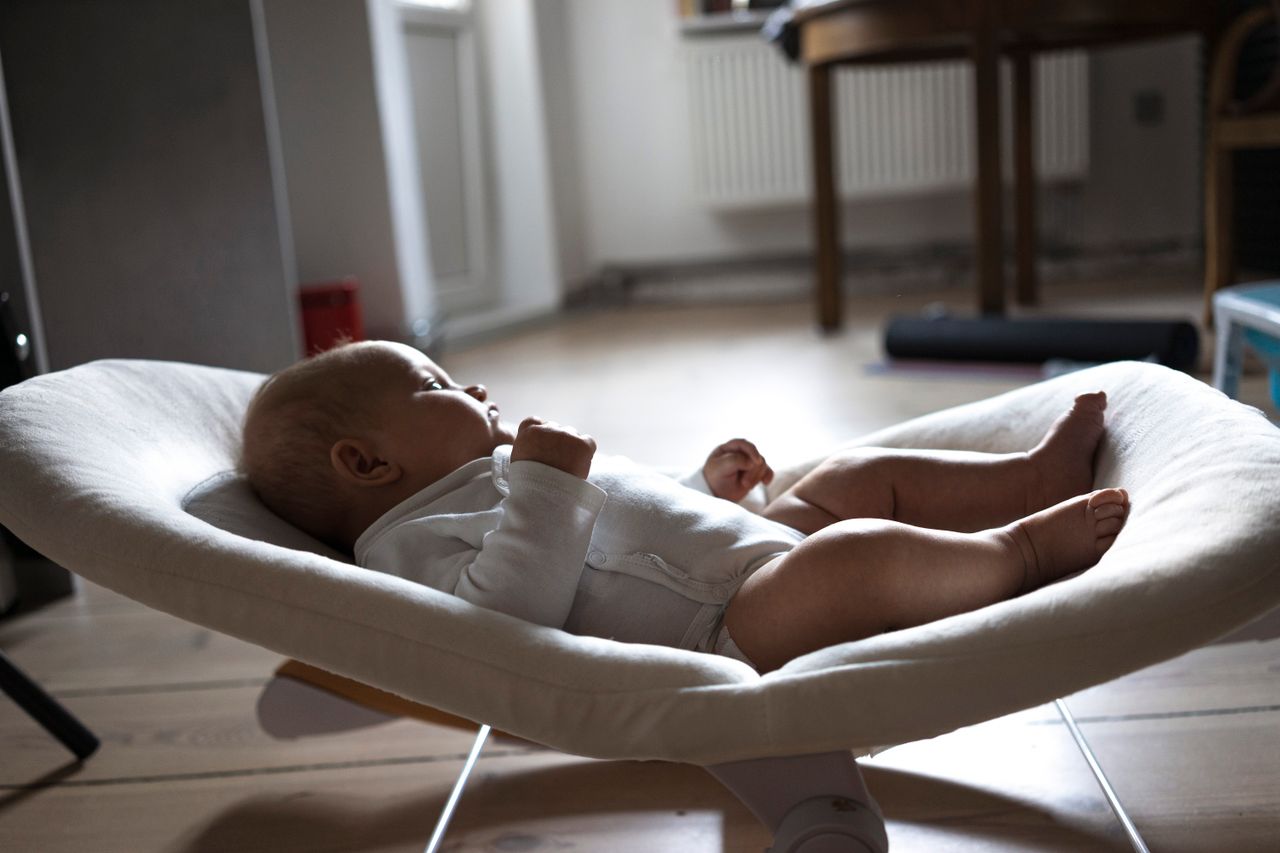 Adorable baby lying in a modern interior setting, showcasing comfort and warmth.